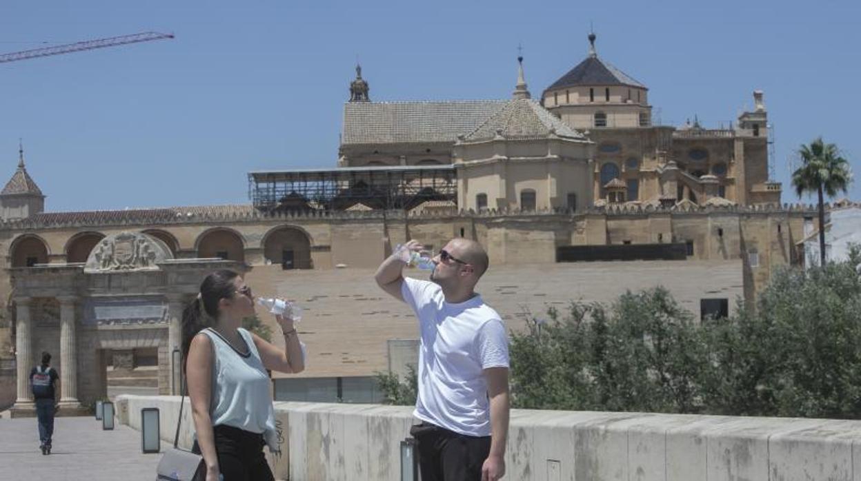 Dos viandantes se refrescan el pasado día 22 de junio en Córdoba