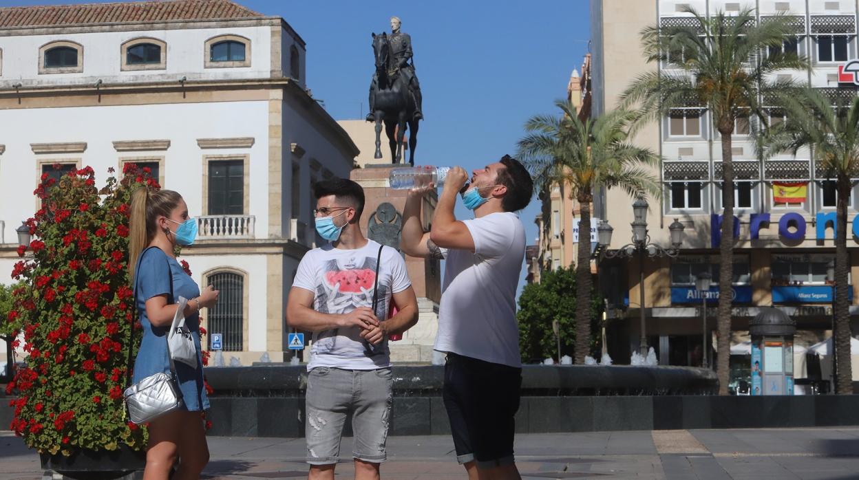 Un joven bebe agua para refrescarse en la plaza de las Tendillas