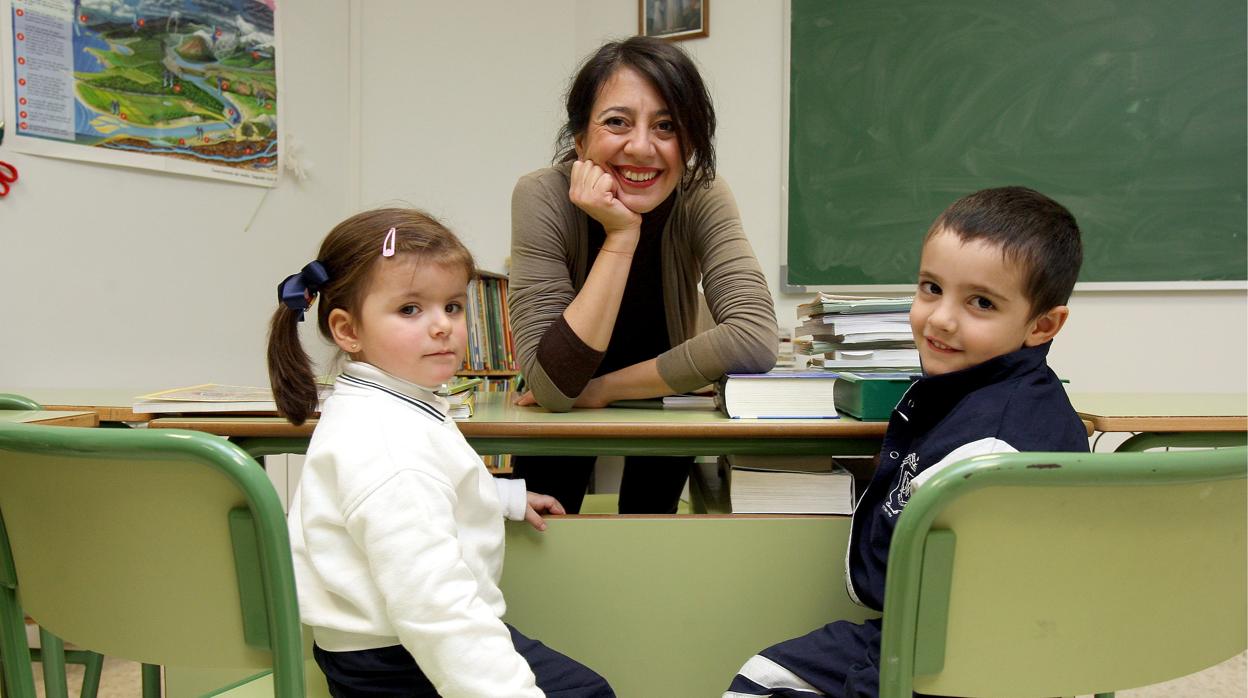 Una profesora de un centro de Córdoba posa con dos alumnos antes de la crisis sanitaria