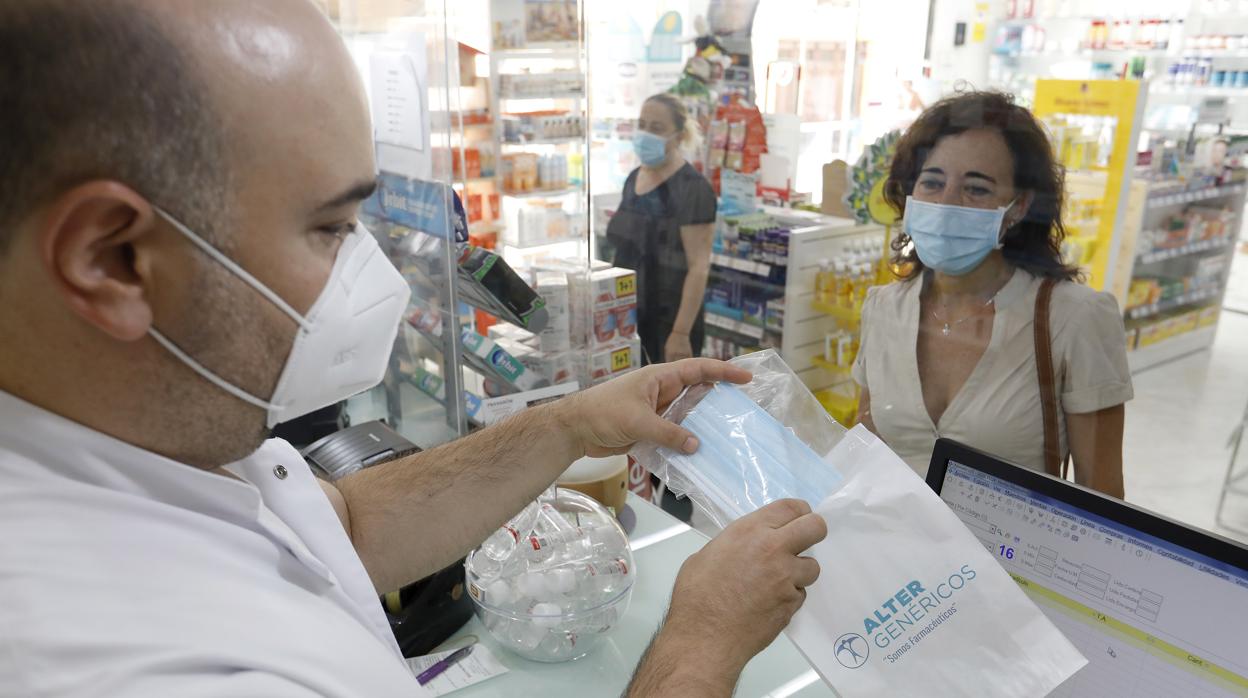 Una mujer compra una mascarilla en una farmacia de Córdoba