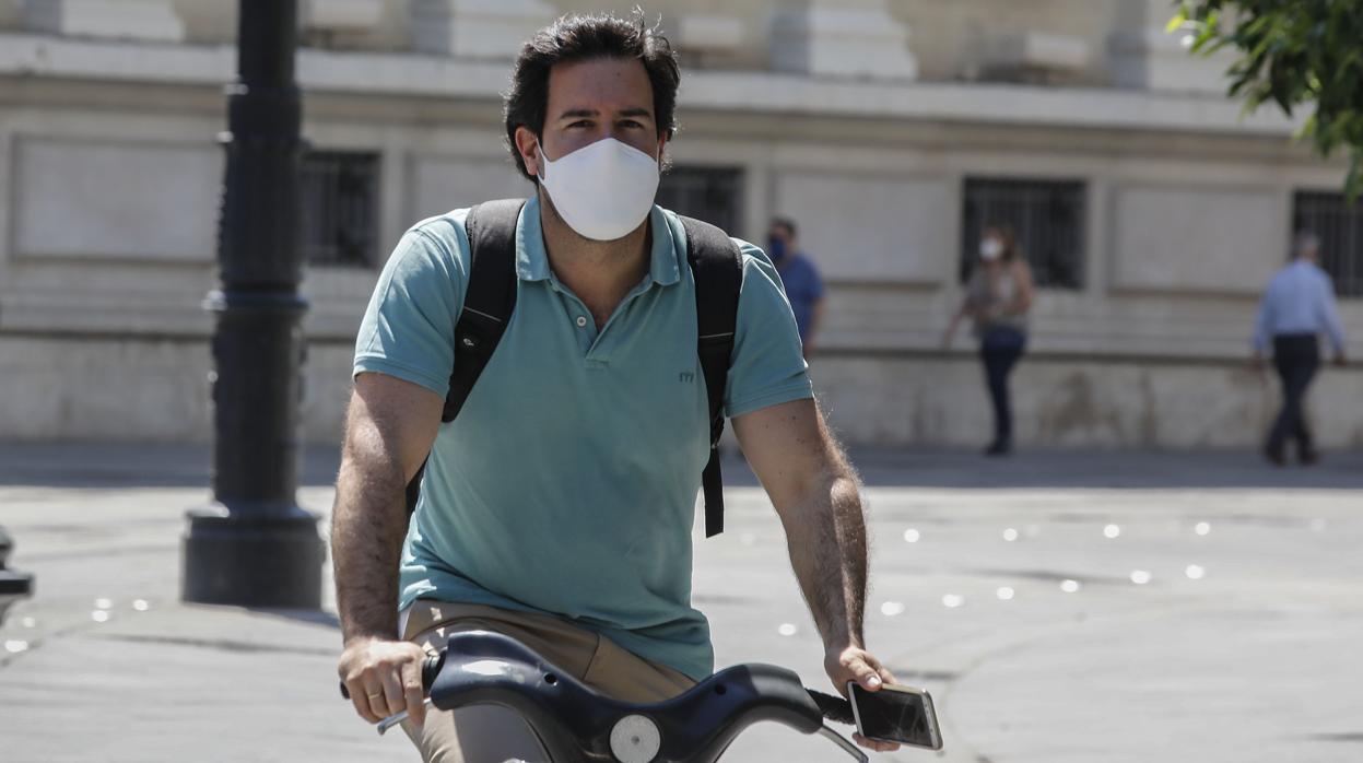 Un ciclista con mascarilla por la avenida de la Constitución