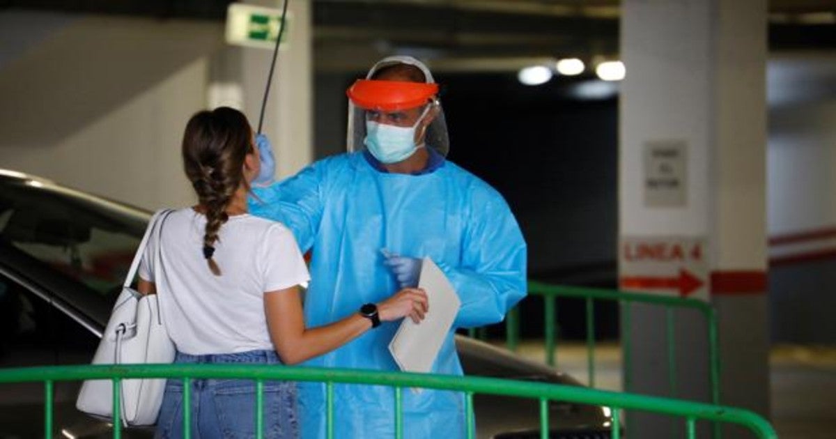 Un sanitario toma muestras a una joven en el Autocovid del centro de salud Carlos Castilla del Pino