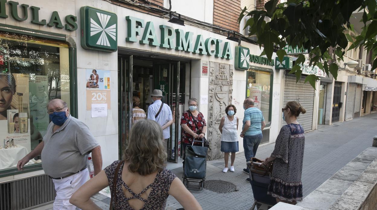 Un grupo de personas espera en la puerta de una farmacia en Córdoba