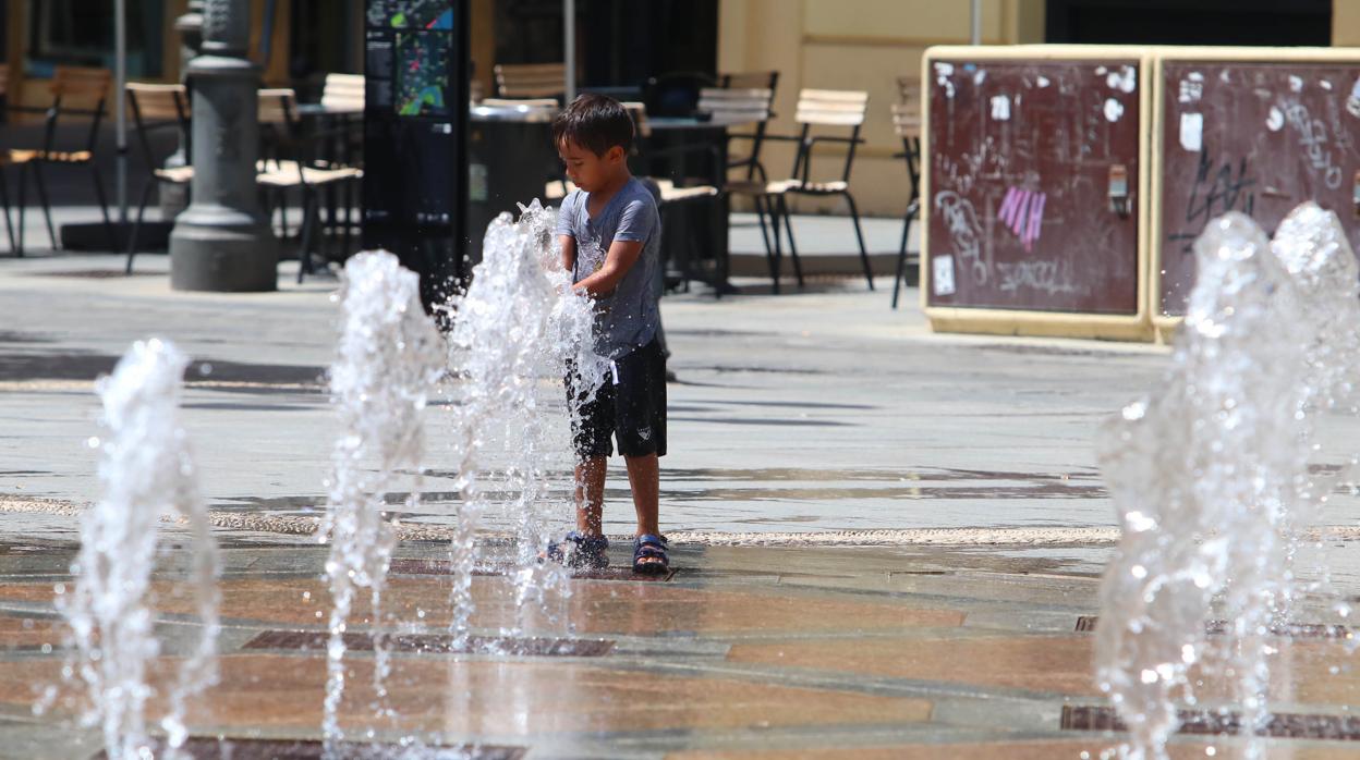 Un niño se refresca en la Plaza de las Tendillas de Córdoba