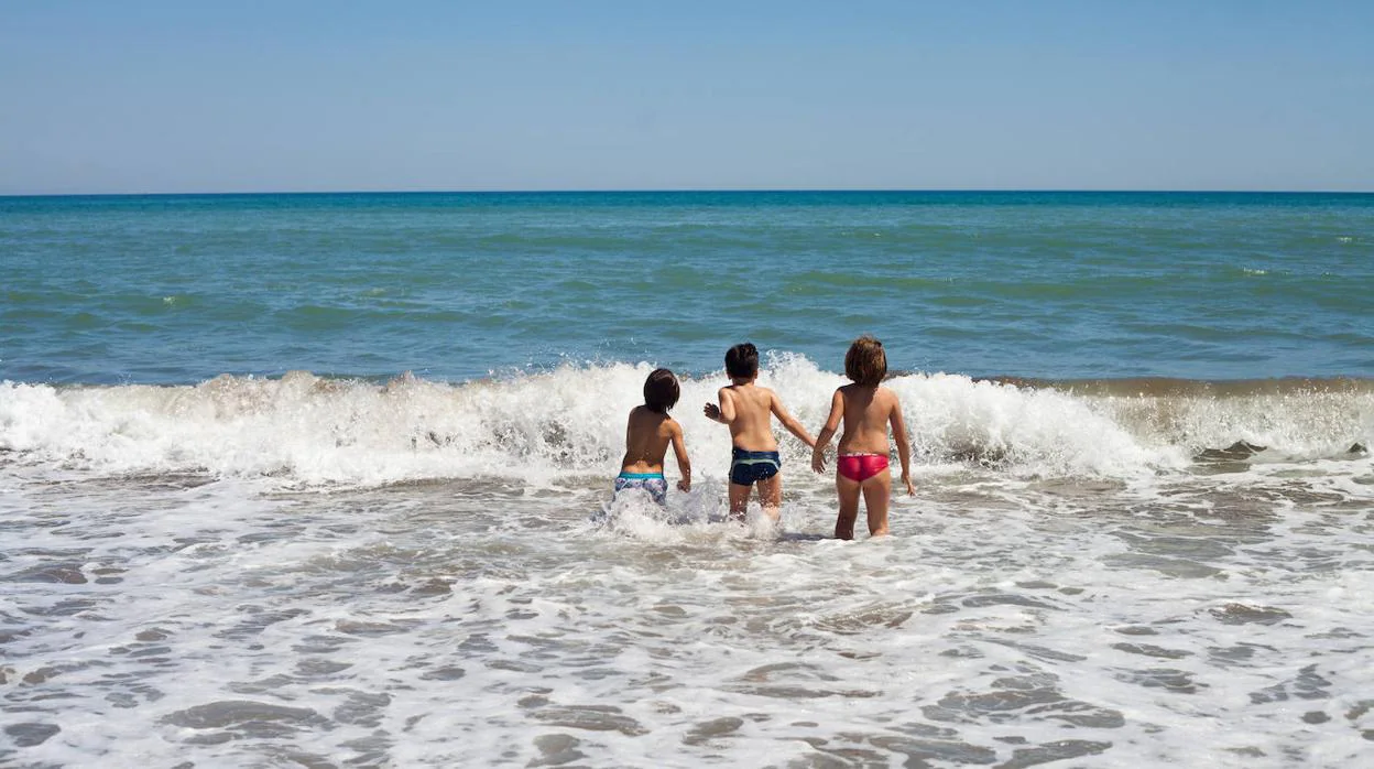 Tres niños se bañan en el mar en una playa de Andalucía