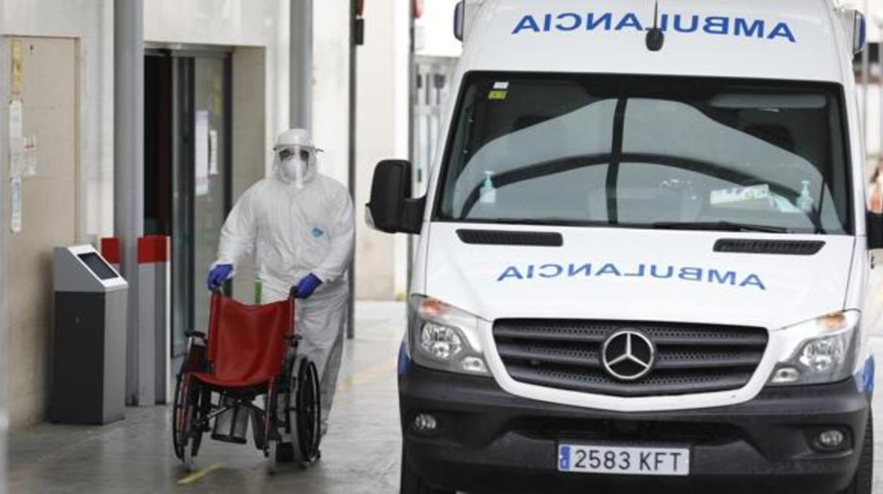 Un sanitario lleva una silla de ruedas a las puertas de un hospital en Córdoba