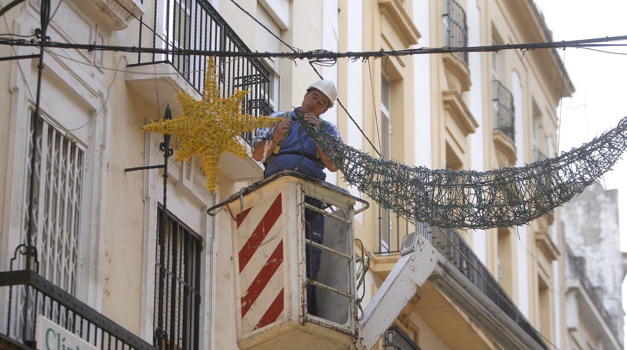 Operario instalando luces navideñas en una ciudad andaluza