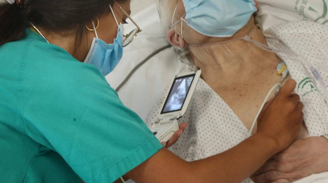 Una sanitaria realiza una ecografía a un paciente en las Urgencias del hospital Reina Sofía