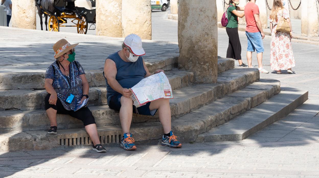 Unos turistas en los alrededores de la Catedral de Sevilla con mascarillas