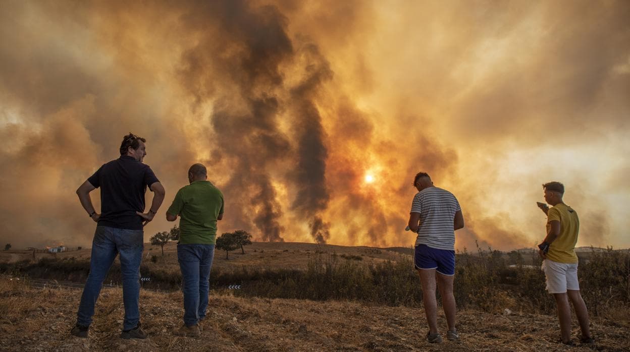Vecinos de Zalamea la Real observan las labores de extinción del incendio forestal de Almonaster