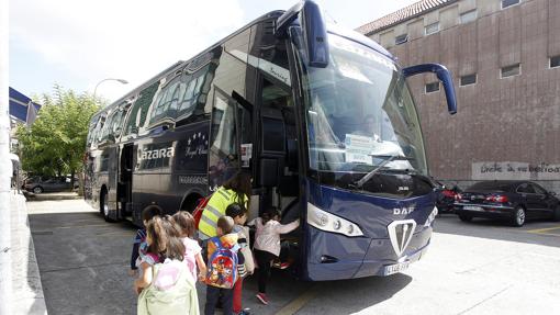 Imagen de archivo de niños subiendo a su autobús escolar