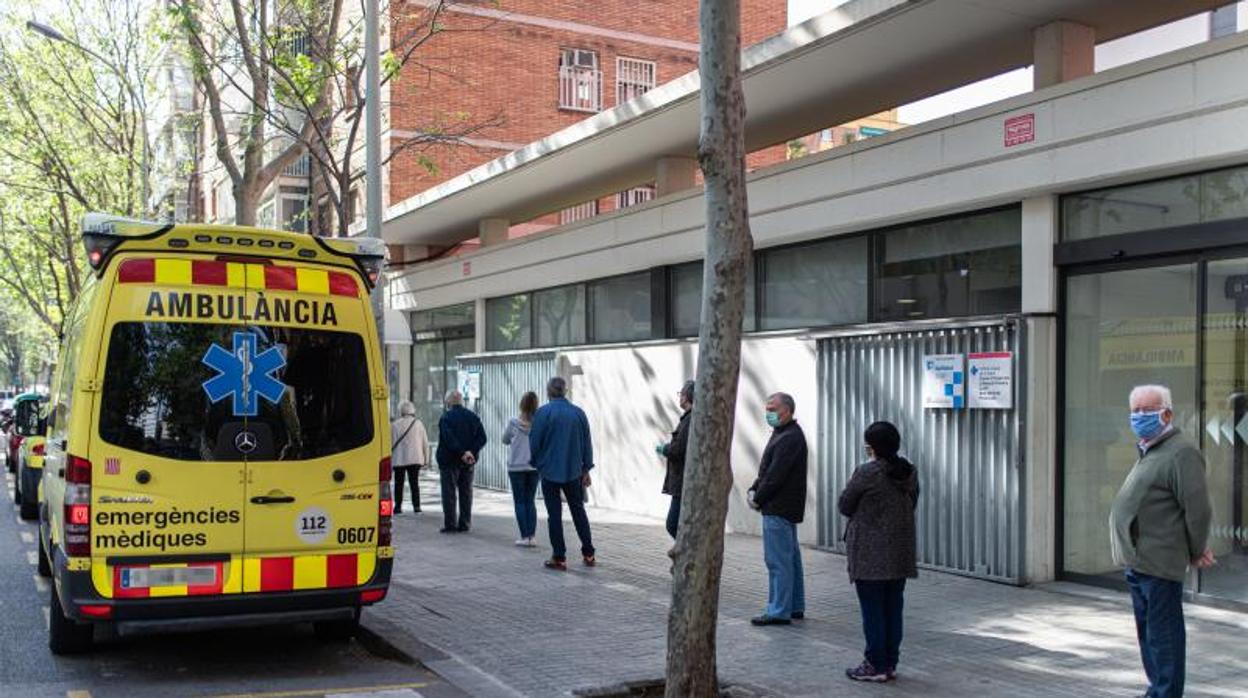 Personas en un centro de salud guardando cola por las medidas de seguridad del Covid-19