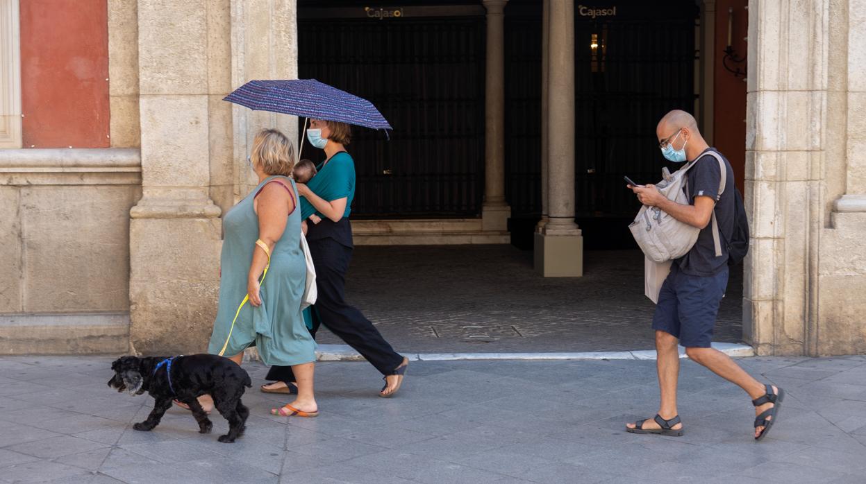 Gente haciendo turismo por Sevilla este verano