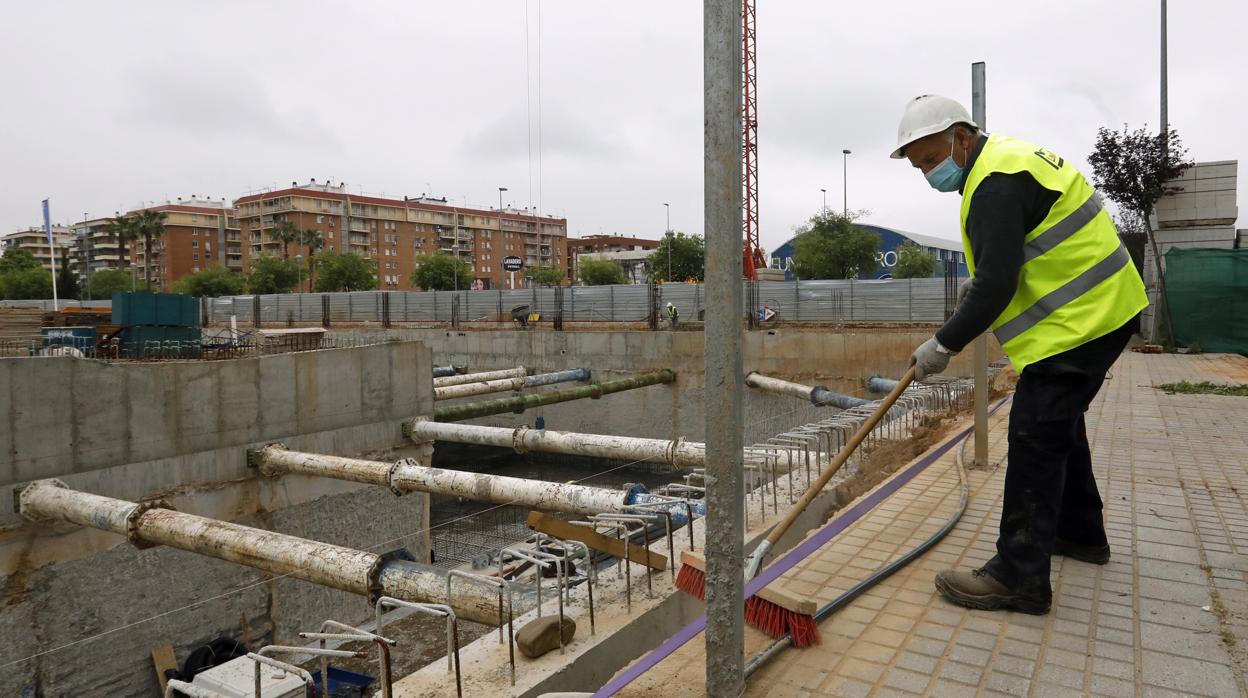 Un albañil limpia la zona de obras en un edificio de nueva construcción