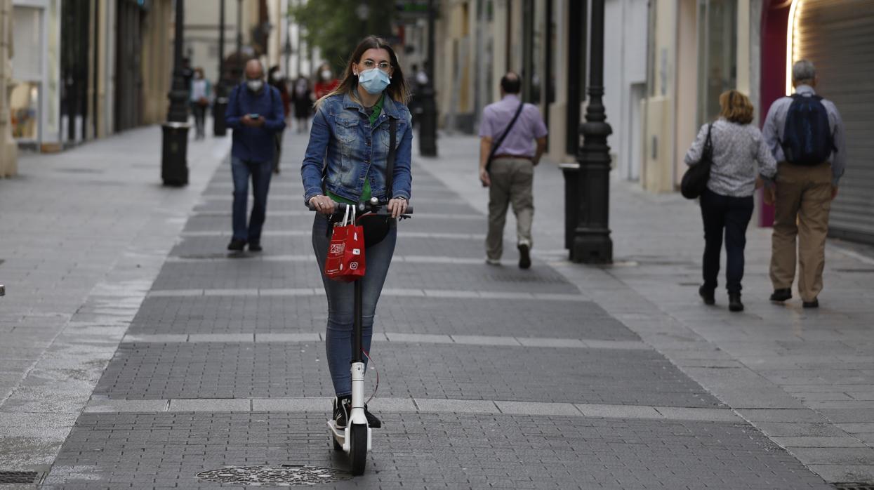 Una joven circula en patinete por la calle Gondomar