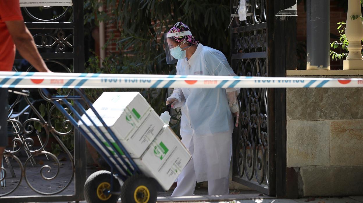 Una trabajadora desinfecta los paquetes a la entrada de una residencia de mayores