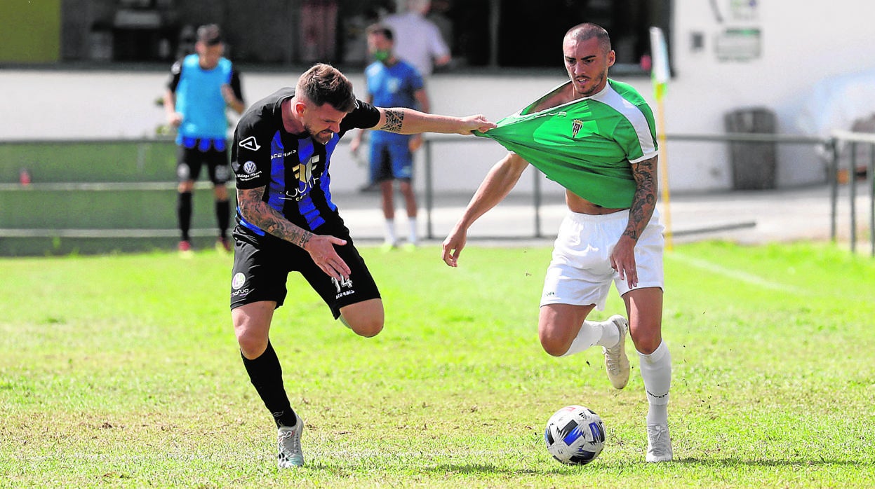 El extremo del Córdoba CF Moutinho es agarrado por un rival en el partido en Torremolinos