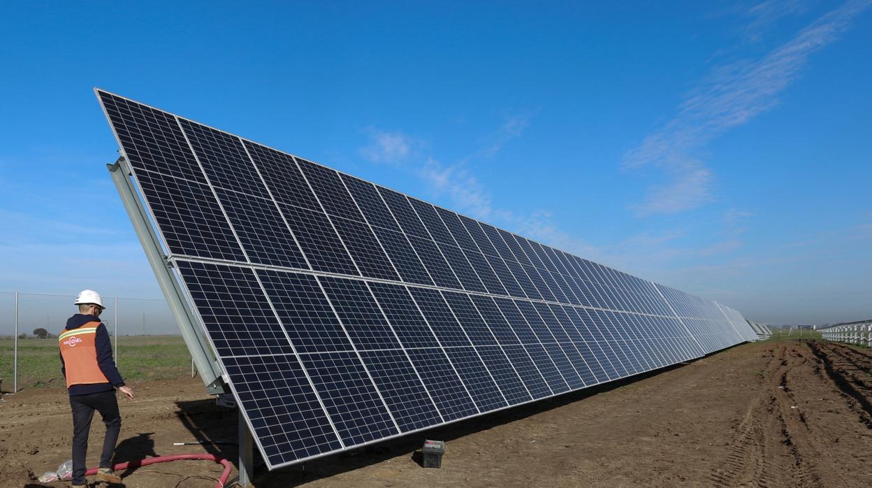 Un operario junto a una placa fotovoltaica