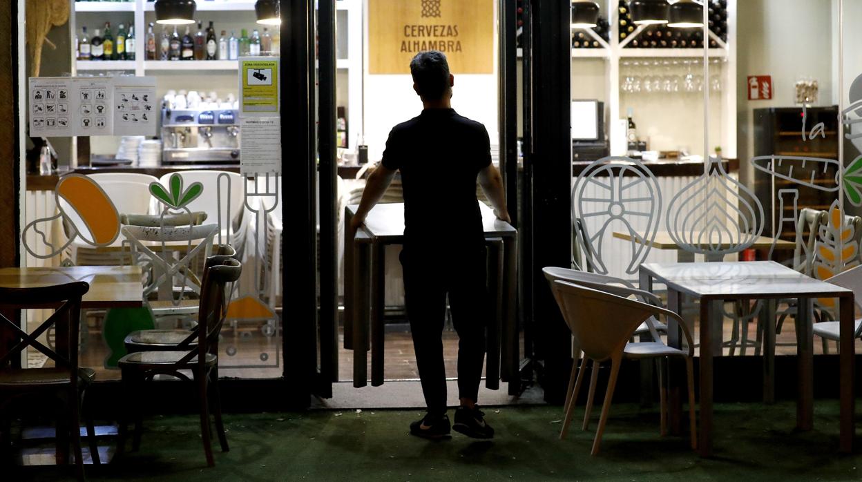 Un camarero recoge los veladores de un bar de Córdoba este sábado