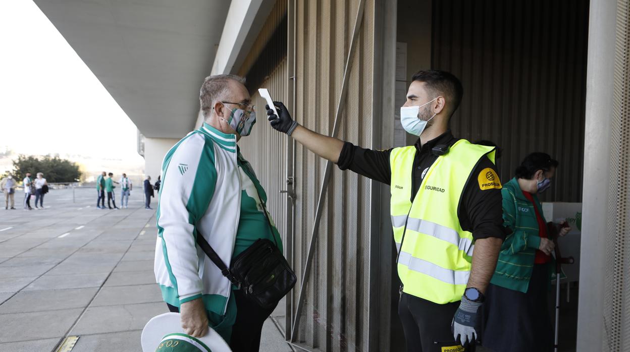 Un responsable de seguridad toma la temperatura a un aficionado en El Arcángel