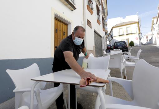 Un trabajador de un bar de Almodóvar desinfecta una mesa