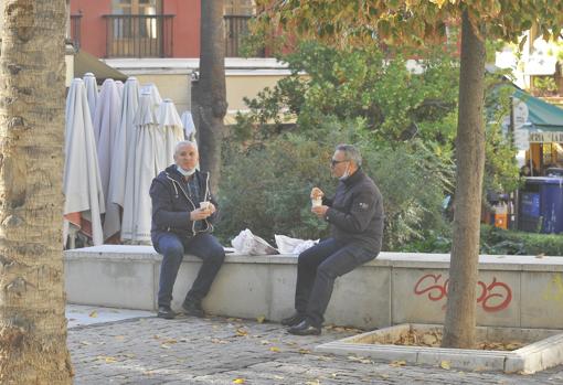 Dos amigos desayunan en la calle en un paréntesis del trabajo