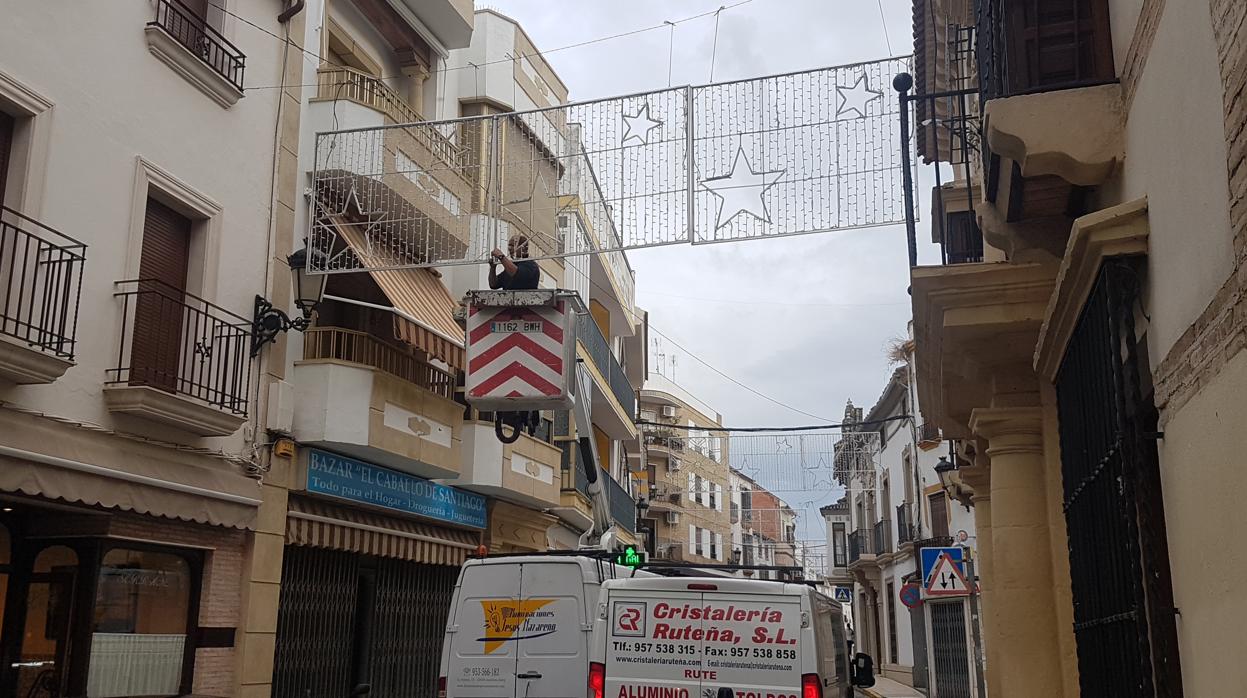 Un operario fija las luces navideñas en Aguilar de la Frontera