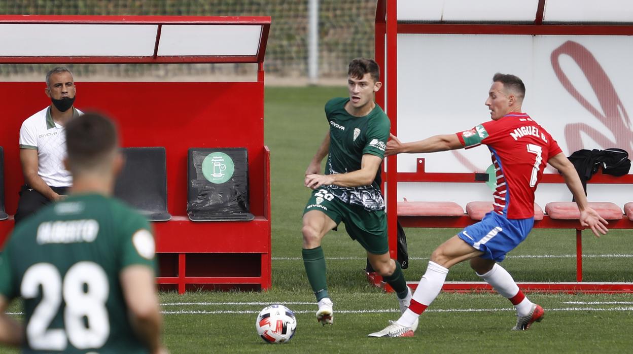 Berto Espeso conduce el balón ante Migue García en el Recreativo Granada-Córdoba CF