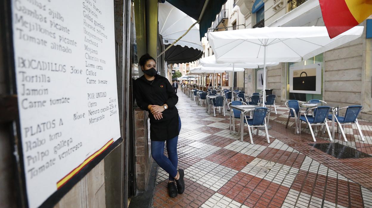 Una camarera espera la llegada de clientes en un bar de la calle La Plata de Córdoba