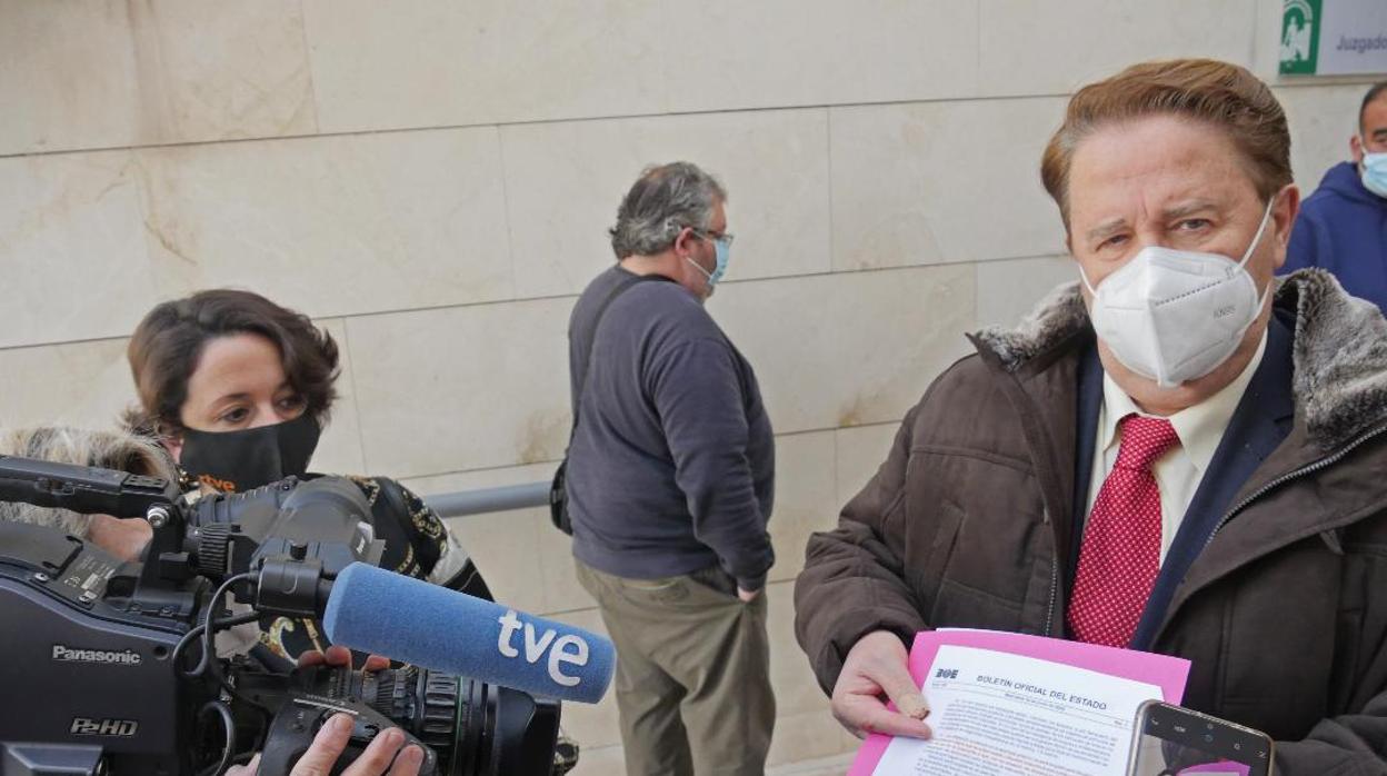 Manuel García, al fondo, mientras su abogado atiende a los periodistas