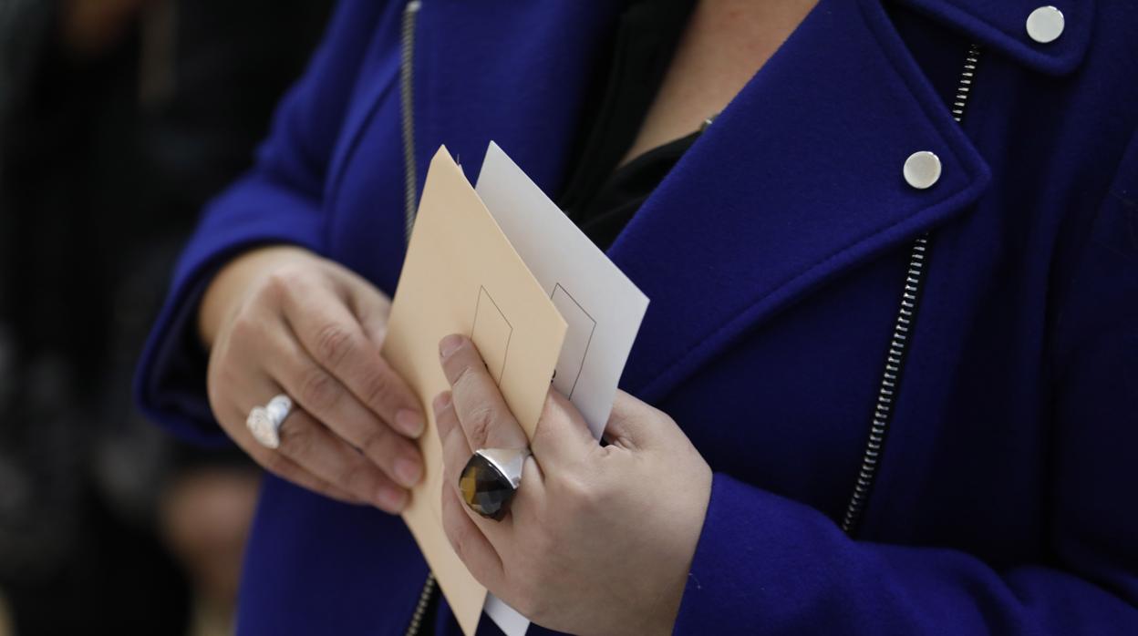 Una mujer prepara sus papeletas para votar en Córdoba