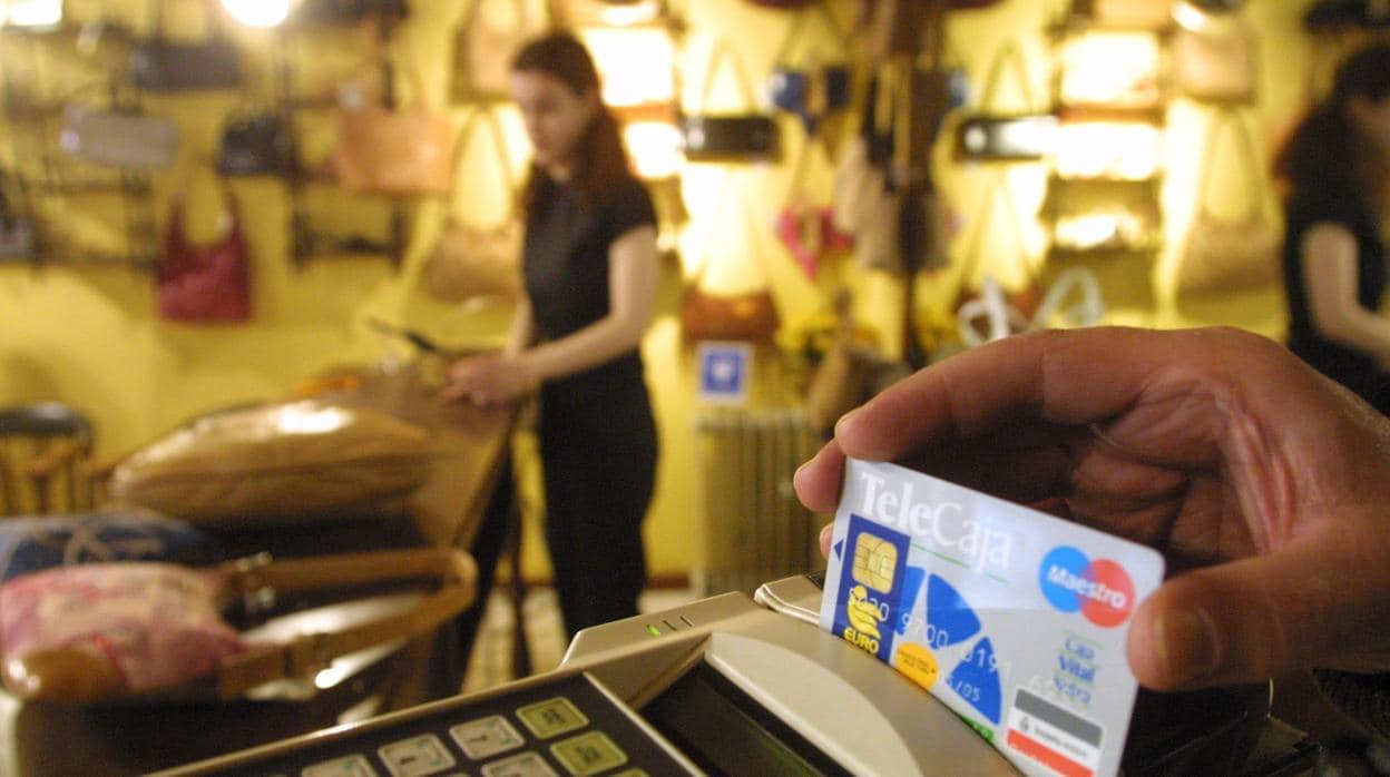 Un usuario pasa una tarjeta de crédito en un comercio