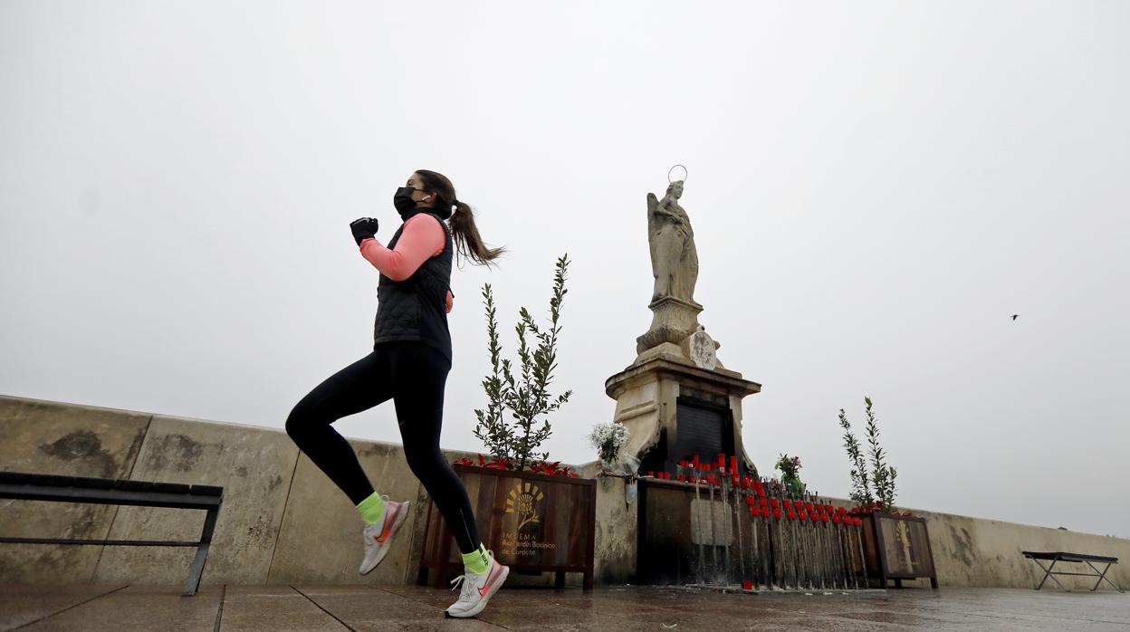 Una joven hace deporte por el Puente Romano en Córdoba