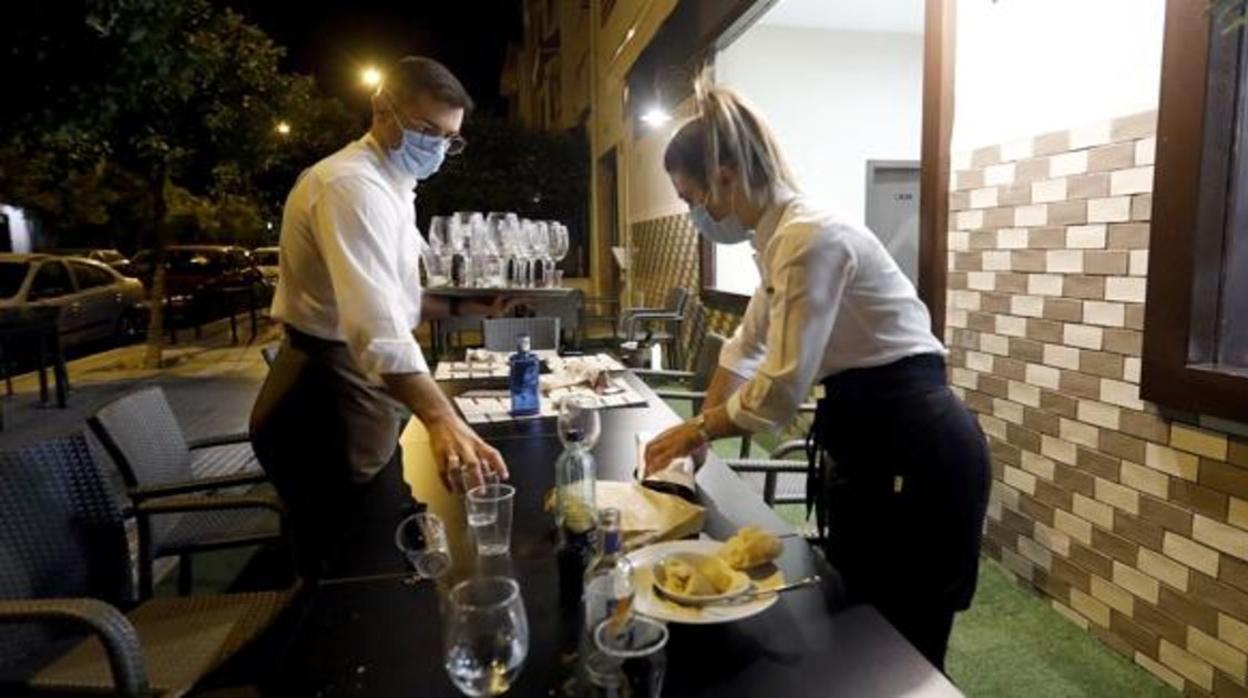 Dos camareros preparan un servicio en un bar