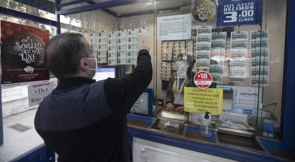 Una persona compra un décimo para el Sorteo de Navidad en una adminsitración de Ciudad Jardín