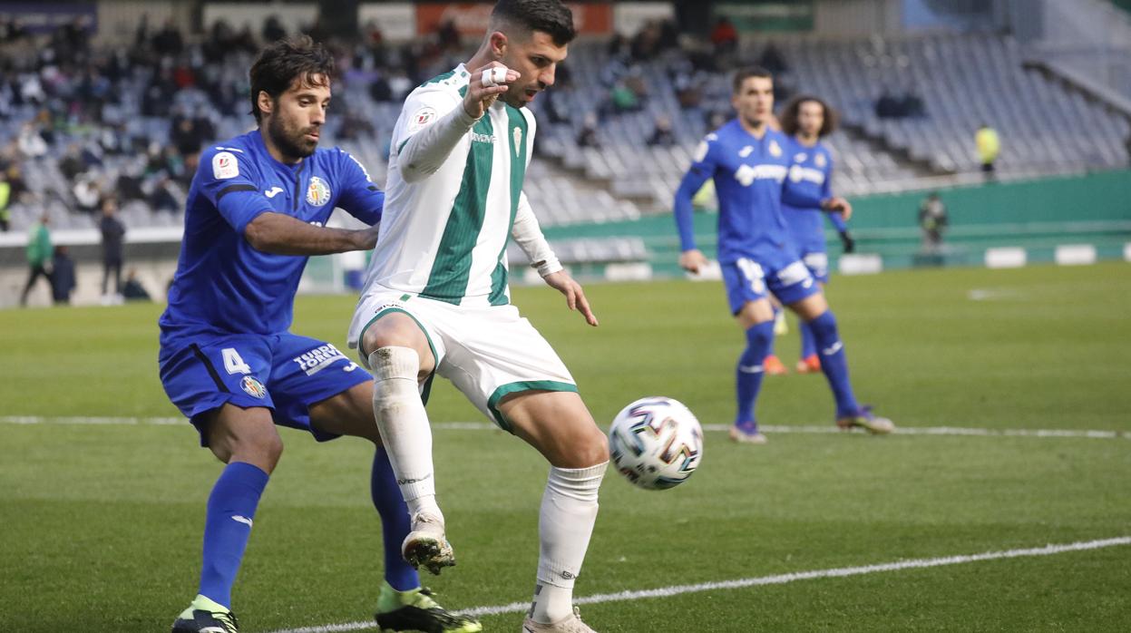 El delantero del Córdoba CF Willy Ledesma controla un balón ante Etxeita, del Getafe