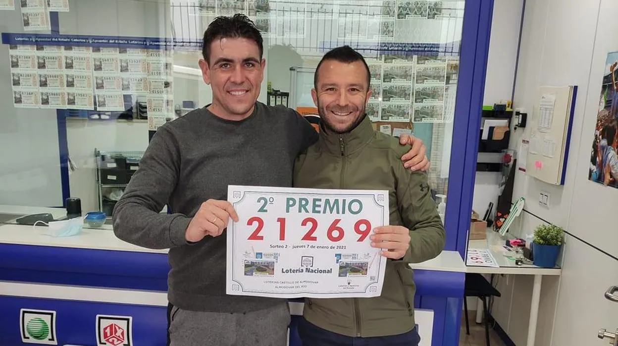 Pepe Díaz, a la derecha, posa con uno de los premiados en el sorteo de la Lotería Nacional