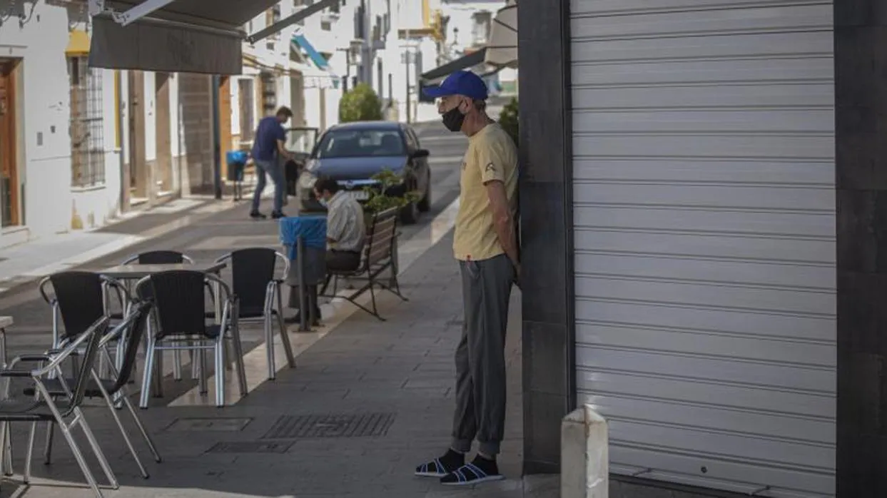 Un vecino de Casariche en la puerta de un bar cerrado en una jornada de confinamiento por la alta incidencia del coronavirus el pasado verano