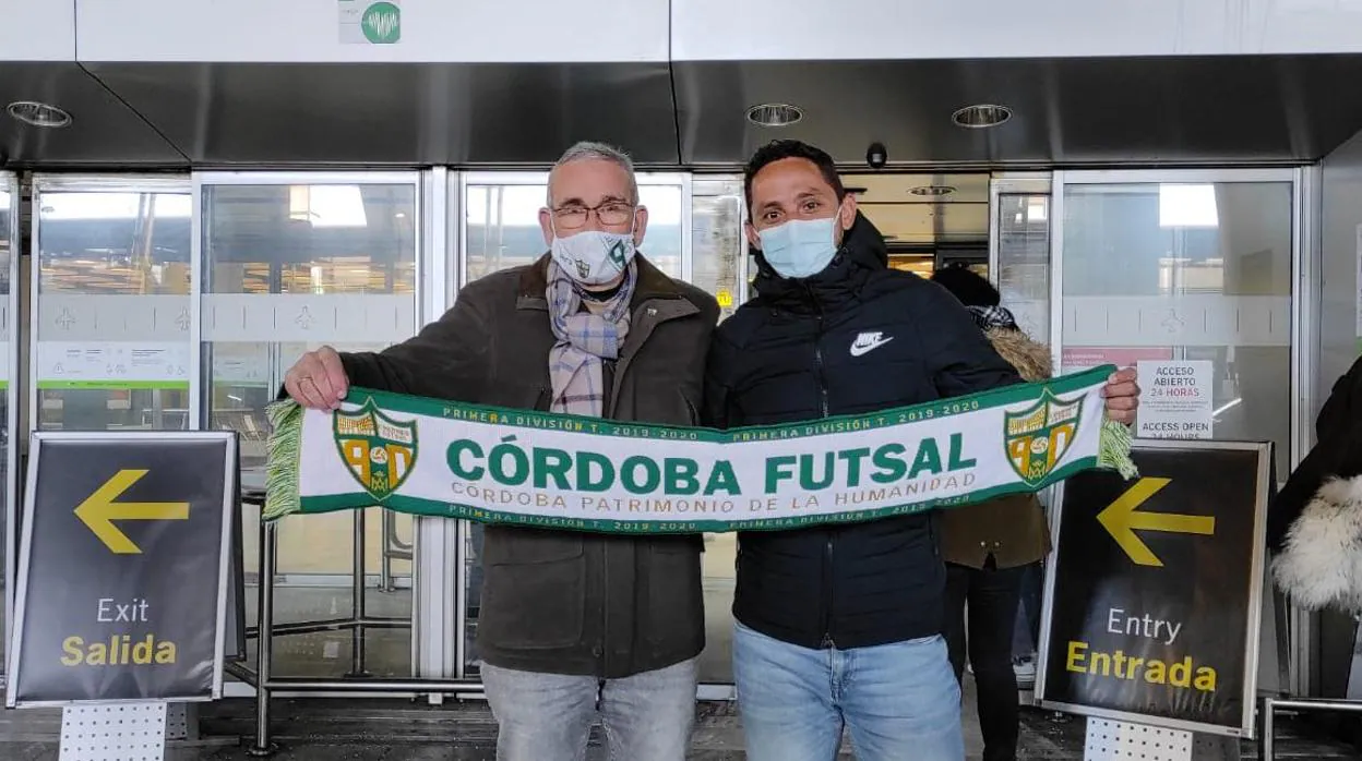 Rafael Jiménez y Caio Cesar posan esta mañana con una bufanda del equipo en el aeropuerto de Madrid