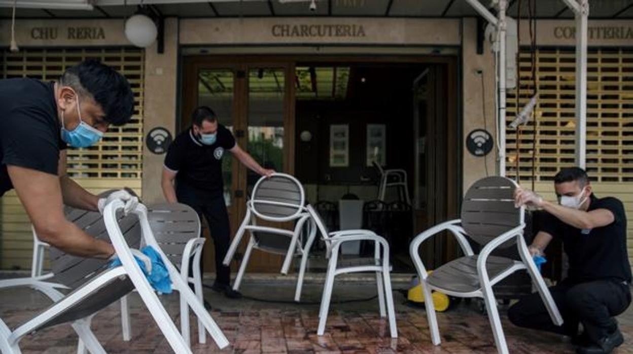 Varios empleados montan la terraza de un establecimiento en el centro de Málaga