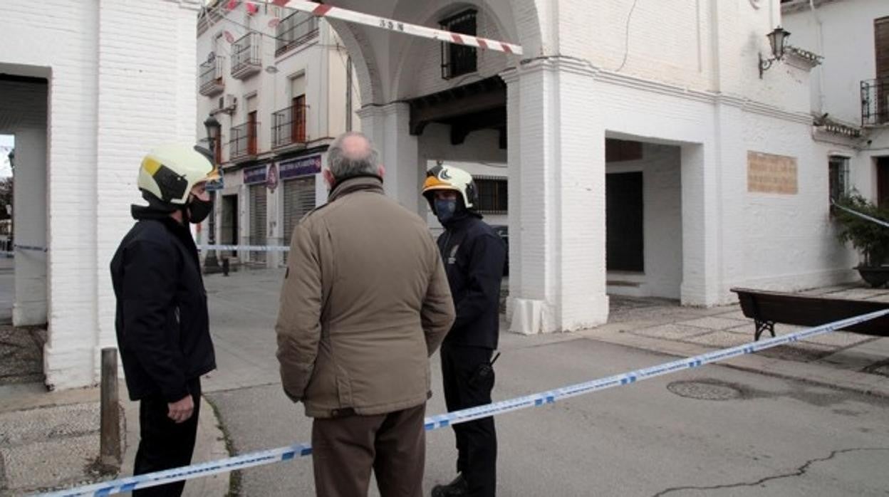 Dos bomberos charlan con un vecino junto a una zona acordonada en Santa Fe