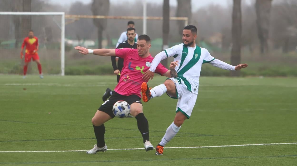 Diego García (Córdoba B) frena una acción de Adrián (Lucena) este domingo en la Ciudad Deportiva