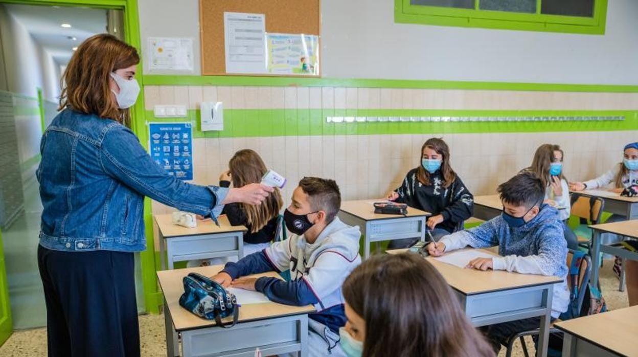 Una profesora toma la temperatura a un alumno en una imagen de archivo