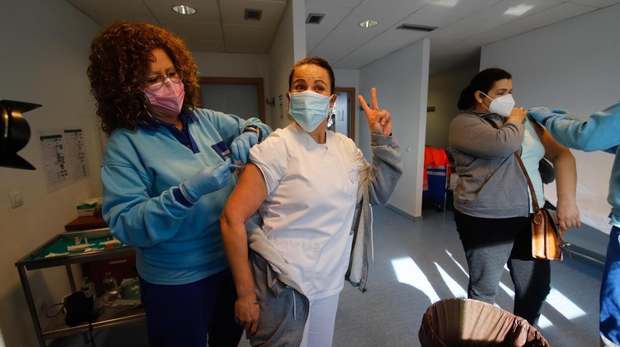 Una trabajadora de la Dependencia hace la señal de la victoria tras ser vacunada contra el Covid-19 en un centro de Salud de Córdoba