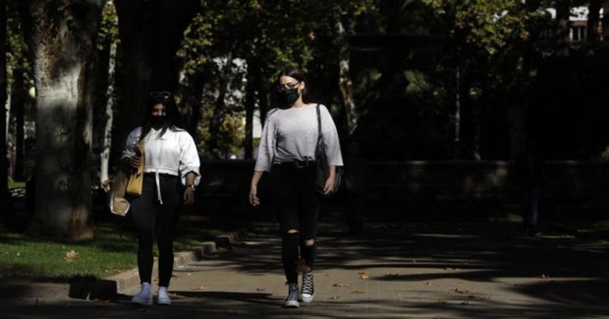 Dos jóvenes pasean al sol por el parque de Colón de la capital