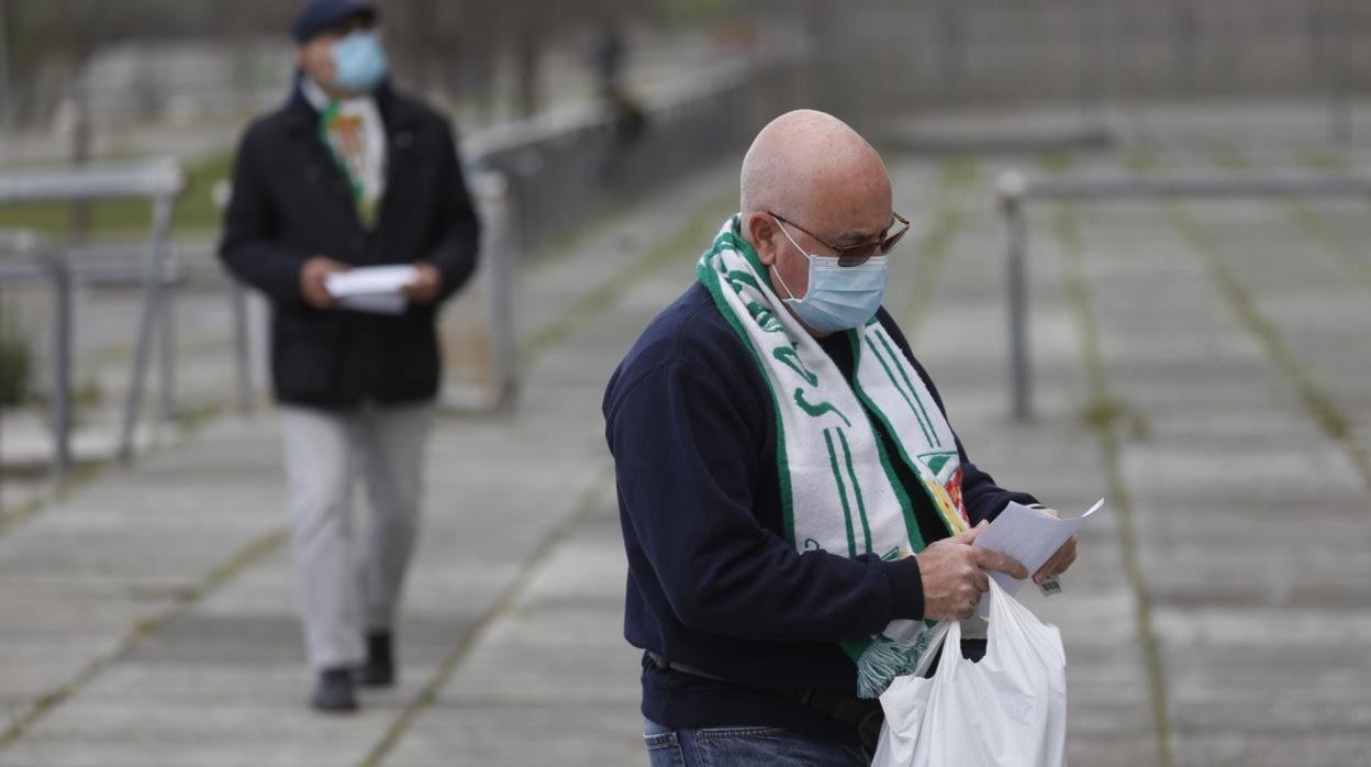 Un abonado del Córdoba CF consulta una hoja antes de entrar al estadio este domingo