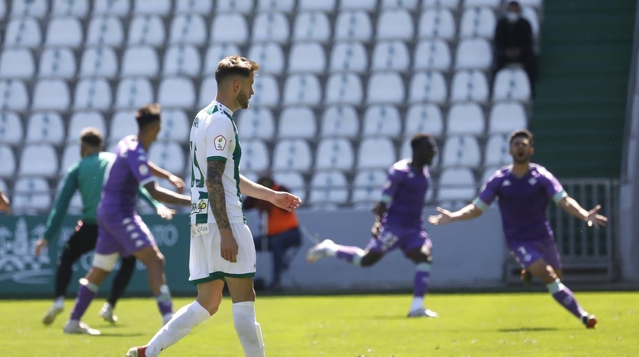 Un jugador blanquiverde avanza triste por el Arcángel ante la alegría del Betis Deportivo este domingo