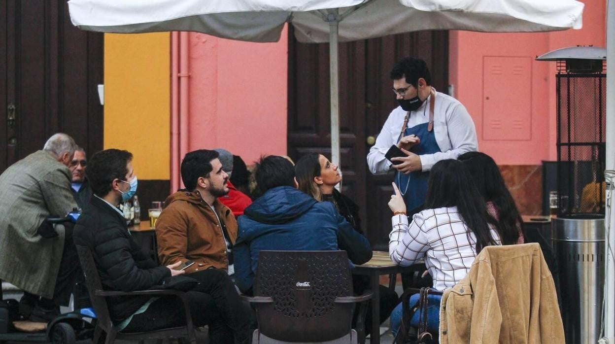 Un camarero atiende a los clientes en un bar de Sevilla