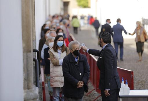 Un hermano toma la temperatura a las personas que llegn hasta la iglesia de los Dolores