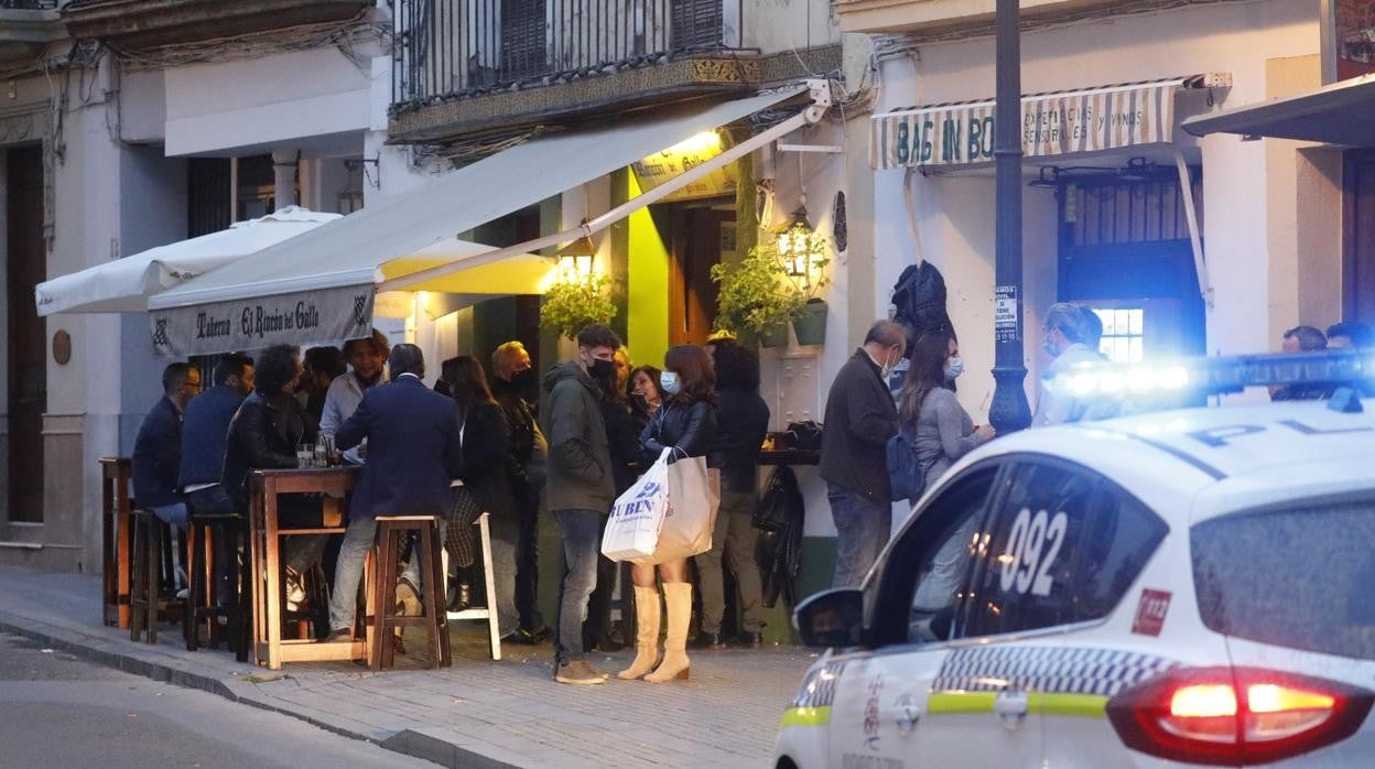 Terraza de bares en Córdoba con un coche de Policía Local aproximándose